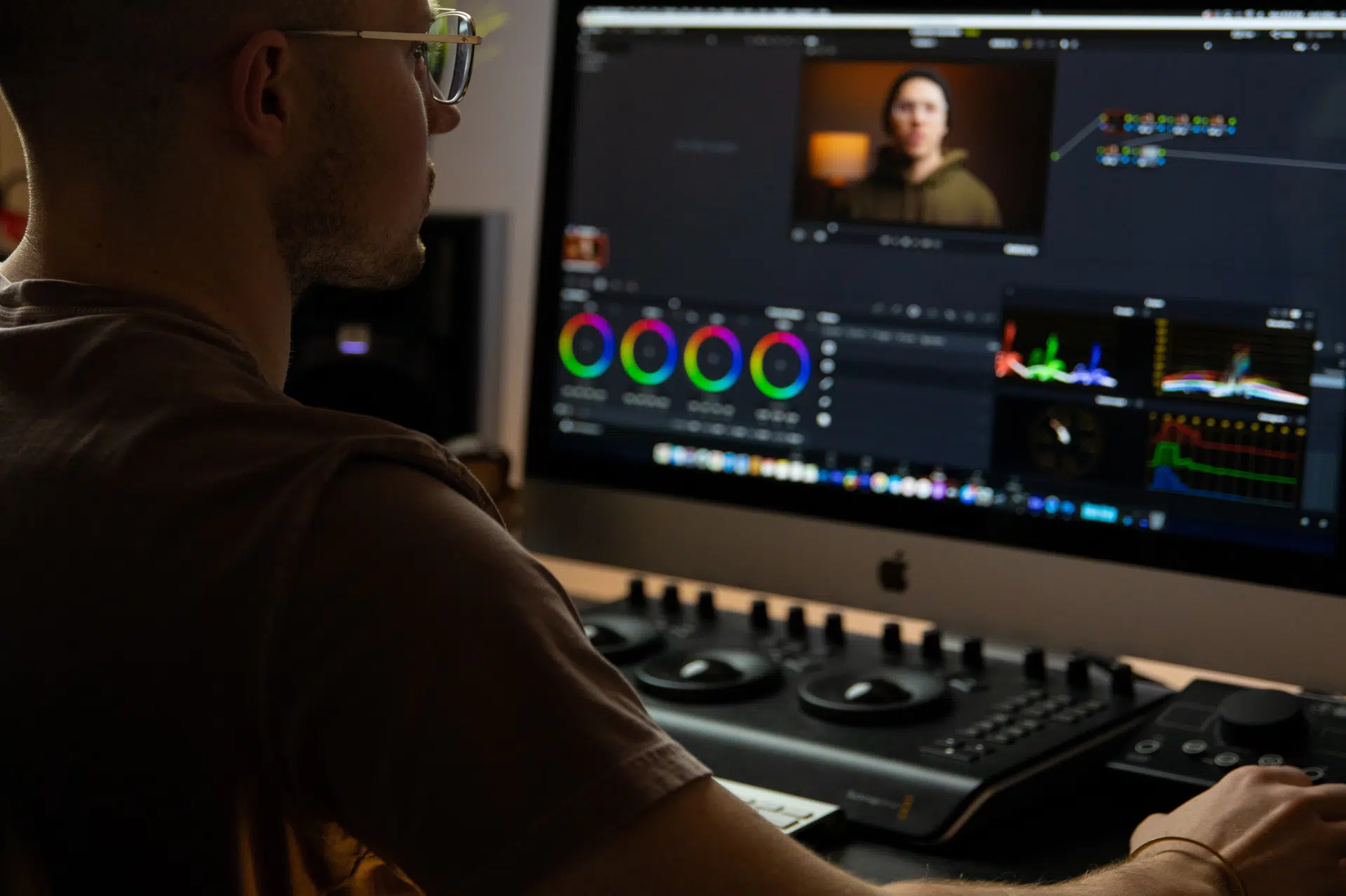 En man arbetar med videoredigering på dator i dämpad belysning